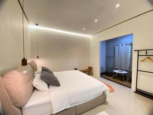 a bedroom with a white bed and a window at Nature Fruit Farm - Private Estate in Balik Pulau