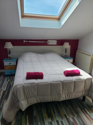 a bedroom with a bed with two red pillows on it at Les Gîtes de Brives in Brives-sur-Charente