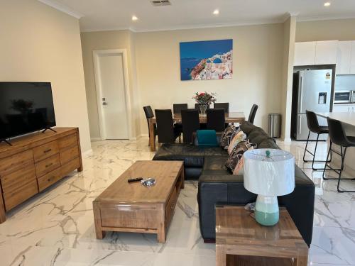 a living room with a couch and a table at Modern house between Airport and Sea in Seaton