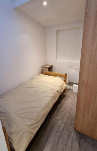 - une petite chambre avec un lit et une baignoire dans l'établissement Appartement à Nanterre-Ville, à Nanterre