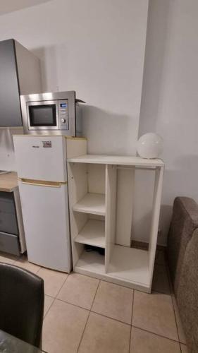 une petite cuisine avec un micro-ondes et un réfrigérateur dans l'établissement Appartement à Nanterre-Ville, à Nanterre