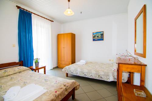 a bedroom with two beds and a table and a table sidx sidx sidx at Armiriki Rooms in Vrasná