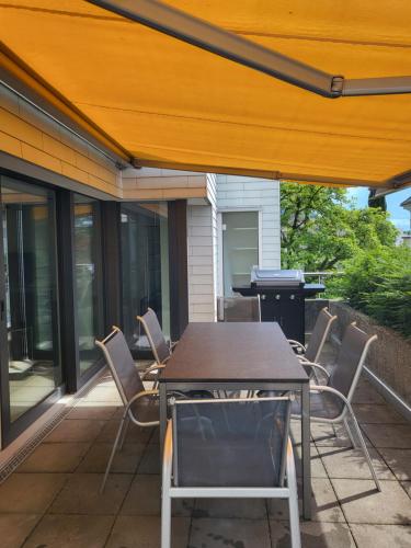 a patio with a table and chairs and a grill at Rigi Paradise in Vitznau, Lake access, Ferry Terminal, Rigibahn, Restaurants all 2 minutes walking distance in Vitznau