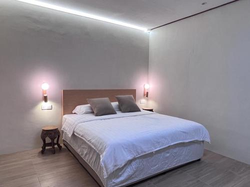 a white bedroom with a large bed with two lamps at Nature Fruit Farm - Private Estate in Balik Pulau
