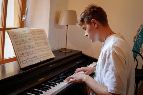 a man playing a piano with at Mana Mana Youth Hostel in Tossa de Mar