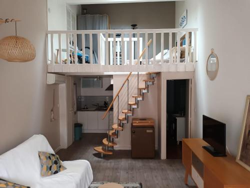 - un salon avec un escalier en colimaçon dans une maison dans l'établissement Jolie appartement centre Palavas les Flots, à Palavas-les-Flots