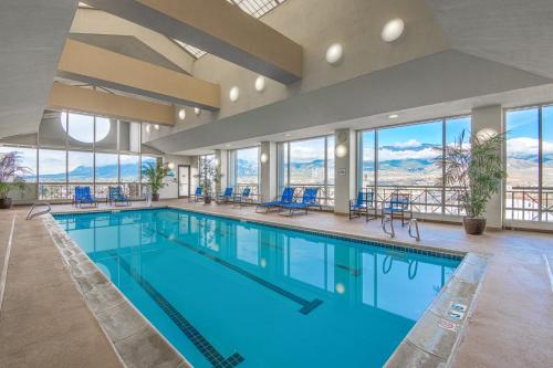 a large swimming pool with blue chairs and windows at The Antlers, a Wyndham Hotel in Colorado Springs