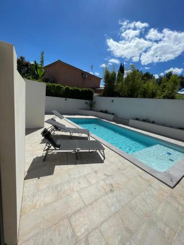 - une piscine avec des chaises longues sur la terrasse dans l'établissement Belle villa avec grande piscine, à Villetelle