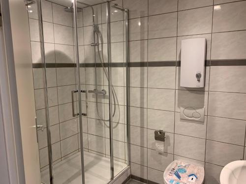 a shower with a glass door in a bathroom at Wohnen am historischen Rathaus in Michelstadt