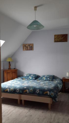 ein Schlafzimmer mit einem Bett mit einer blauen Decke in der Unterkunft Charmante maison dans village in Champcueil