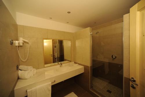une salle de bain avec un lavabo et une douche dans l'établissement Hotel Belvedere Wellness & Family, à Baselga di Pinè