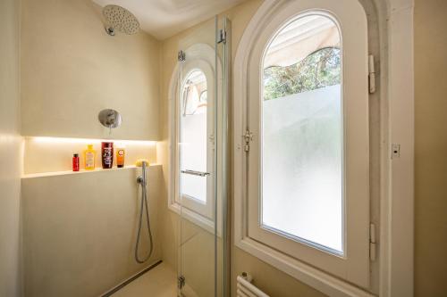 a bathroom with a shower and two windows at PETITE PARAGGI Vista e Comodità sul Mare in Santa Margherita Ligure