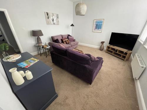 a living room with a couch and a table at Contractors Business Families Relocation Accommodation enjoy Fast WiFi Large Screen Smart TV and SKY Sports in this Spotless Ground Floor apartment in Wakefield