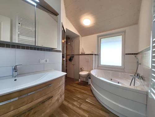 a bathroom with a tub and a sink and a toilet at Seeschwalbe 329 in Mirow