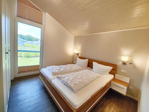 a bed in a room with a large window at Seeschwalbe 329 in Mirow