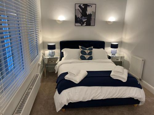 a bedroom with a large bed with two night stands at Contractors Business Families Relocation Accommodation enjoy Fast WiFi Large Screen Smart TV and SKY Sports in this Spotless Ground Floor apartment in Wakefield