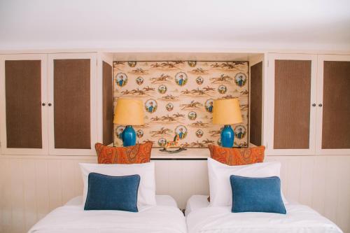 a bedroom with two white beds and blue pillows at Just Like Home - Casa do Cruzeiro in Moledo