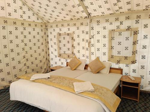 a bedroom with two beds in a room with wallpaper at Paradise North Camp in Hundar
