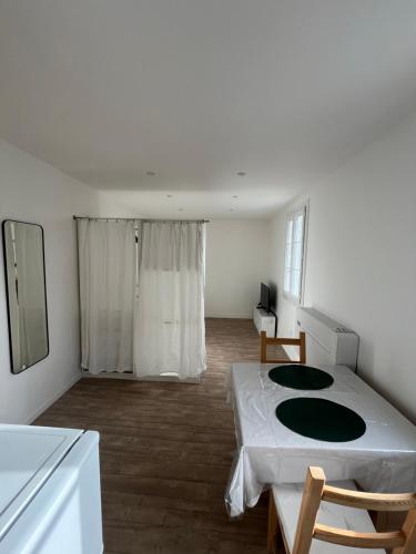 une chambre blanche avec un lit et une table dans l'établissement Studio Intra-Muros idéal festivalier Climatisé, à Avignon