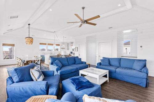 a living room with blue couches and a ceiling fan at Jailbreak in Southport