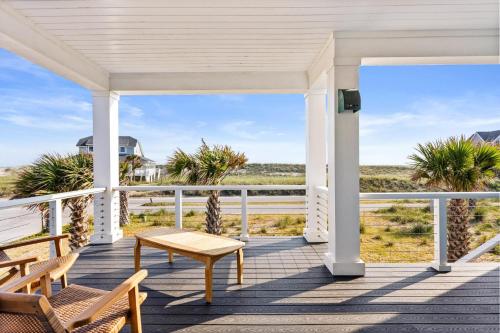 a white porch with a table and chairs on the beach at Jailbreak in Southport