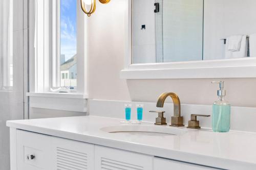 a white bathroom with a sink and a mirror at Jailbreak in Southport