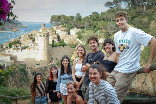 a group of people standing in front of a castle at Mana Mana Youth Hostel in Tossa de Mar