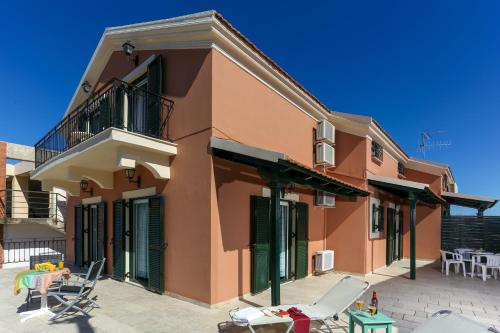 a building with chairs and a patio in front of it at Electra Apartments in Sidari