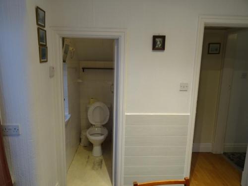a white bathroom with a toilet in a hallway at Dovehouses in Redcar