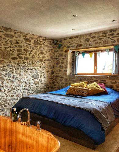 une chambre avec un lit et un lavabo dans l'établissement L'Atelier des Rêves, à Saint-Martial-Entraygues