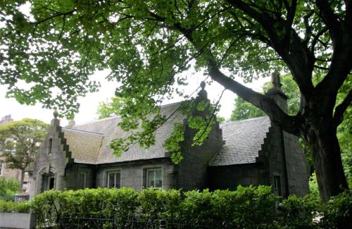 an old stone house with a tree in front of it at Historic Baronial Lodge with Parking, Aberdeen City Centre in Aberdeen