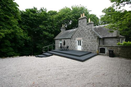 an old stone building with a patio in front of it at Historic Baronial Lodge with Parking, Aberdeen City Centre in Aberdeen