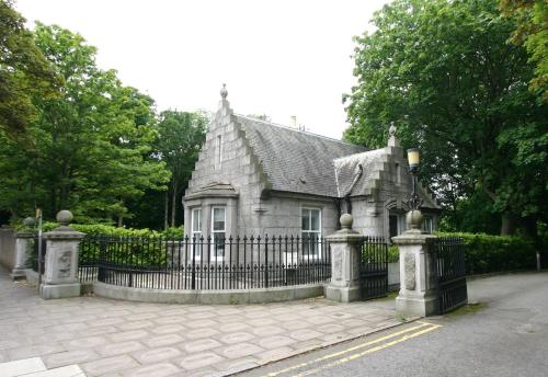 an old house with a fence in front of it at Historic Baronial Lodge with Parking, Aberdeen City Centre in Aberdeen