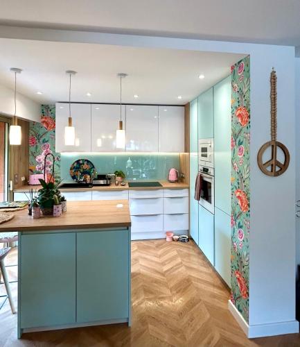 une cuisine avec des armoires bleues et un comptoir dans l'établissement Superbe 3P bohème, Juan les pins, jardin, 900m de la mer, à Antibes