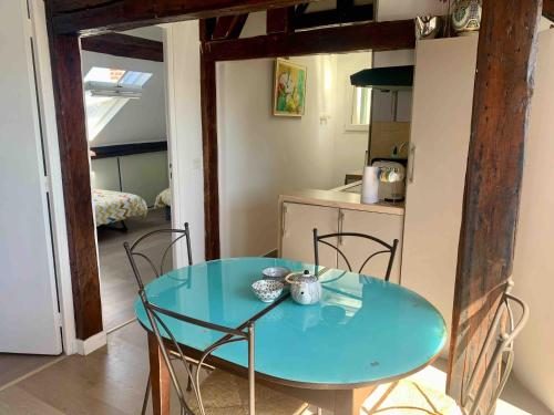 une table et des chaises bleues dans une petite cuisine dans l'établissement Le Fitzgerald -Très joli 3 pièces Art Déco Deauville HyperCentre, à Deauville