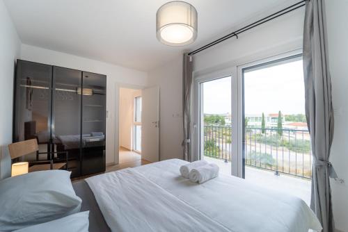a bedroom with a bed and a large window at Rooftop Holiday House in Brodarica