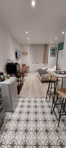 une chambre avec un lit, une table et des chaises dans l'établissement Le Petit B - Lit Neuf- Hyper centre, à Dieppe