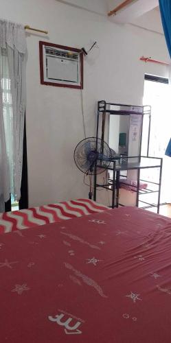 a room with a bed with a red blanket and a table at Villa Juan y Exequila in Anda
