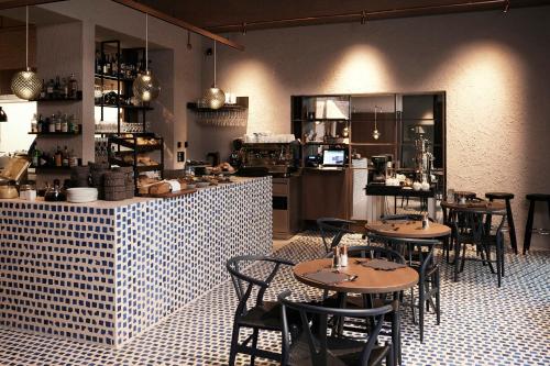 a restaurant with tables and chairs and a kitchen at Boutique Hotel Badhaus in Bressanone