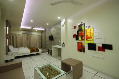 a living room with a bed and a room with a table at Hotel Good Night in Ahmedabad