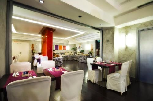 ein Esszimmer mit Tischen und weißen Stühlen und ein Restaurant in der Unterkunft Hotel Ariston in Rom
