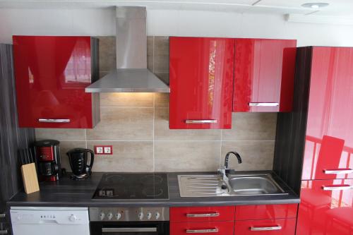 a kitchen with red cabinets and a sink at City Ferienhaus Vulkaneifel in Daun