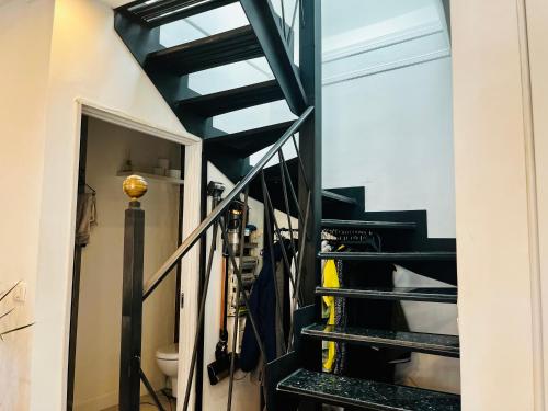 a set of stairs leading up to a room with skis at Évasion en Périgord, appartement exceptionnel in Sarlat-la-Canéda
