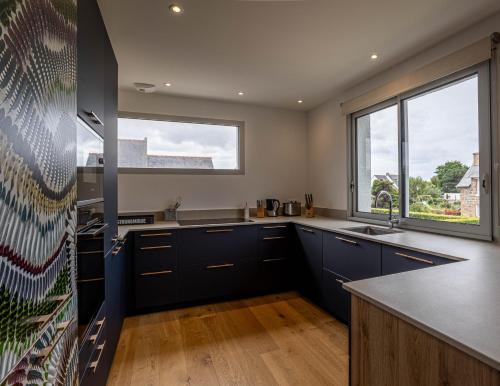 une cuisine avec des placards bleus et une grande fenêtre dans l'établissement TY MARIE, Ploumanach, à Perros-Guirec