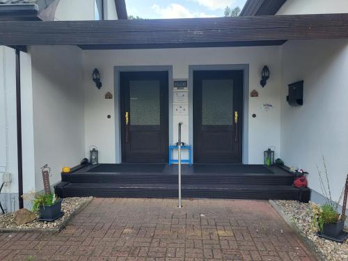 a front porch of a house with blue doors at Haus am Wald - Haus Nils und Haus Nele in Bark