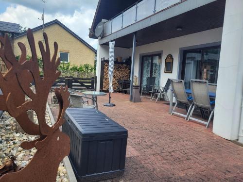 a patio with a trash can and a table and chairs at Haus am Wald - Haus Nils und Haus Nele in Bark