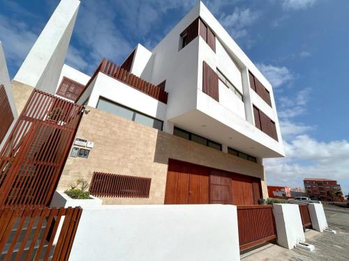 a modern house with a fence in front of it at Papaya Apartments Sal Island in Santa Maria