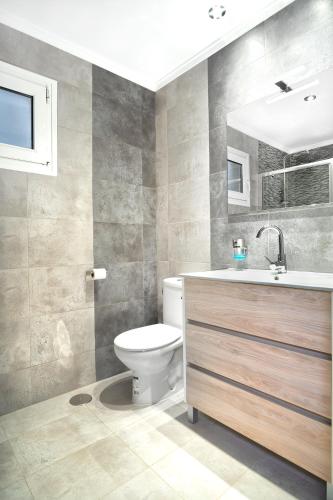 a bathroom with a toilet and a sink and a mirror at Lighthouse Dunamar in La Mata