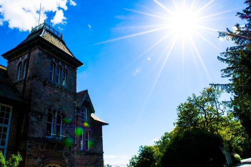 an old building with the sun in the sky at Cumbria Grand Hotel in Grange Over Sands