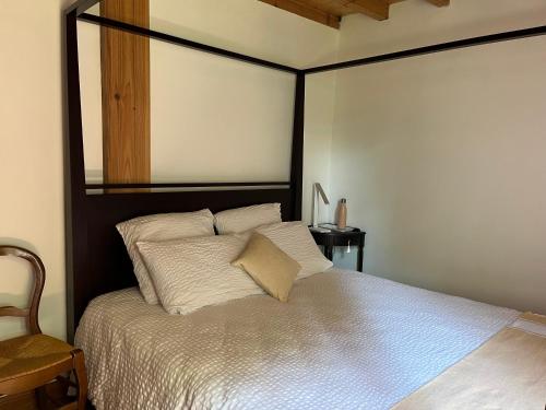 une chambre avec un grand lit avec des draps blancs dans l'établissement Le chêne magique 40200 Léontine, à Pontenx-les-Forges